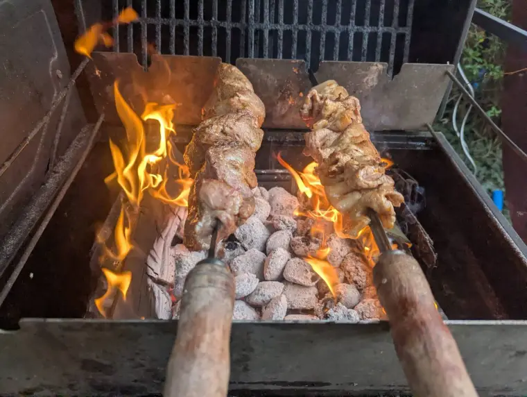 Fleischspieße über Glut und Flammen
